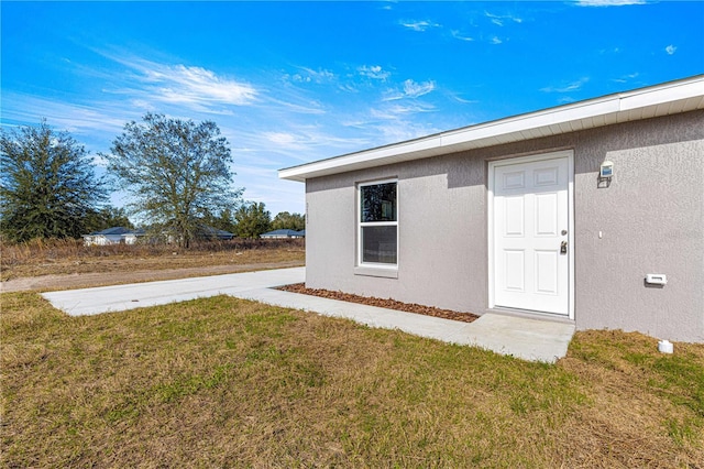 doorway to property featuring a yard