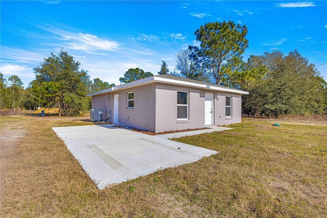 rear view of house featuring central AC unit, a patio area, and a yard