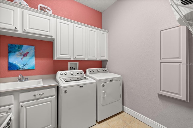 washroom with washer and clothes dryer, sink, light tile patterned flooring, and cabinets