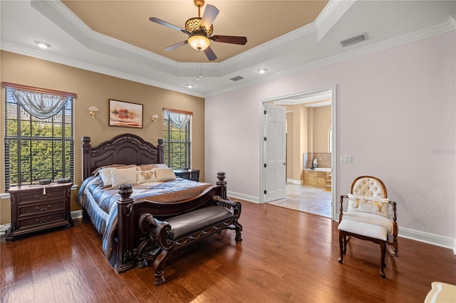 bedroom with ensuite bath, a tray ceiling, ceiling fan, crown molding, and hardwood / wood-style floors