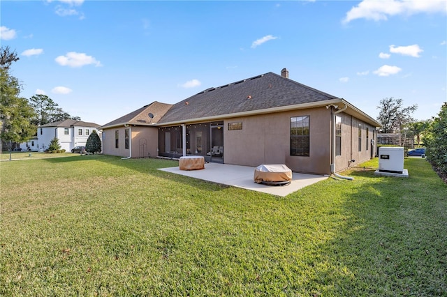 back of house featuring a patio, a sunroom, and a lawn