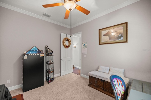 sitting room with ceiling fan, ornamental molding, and light carpet