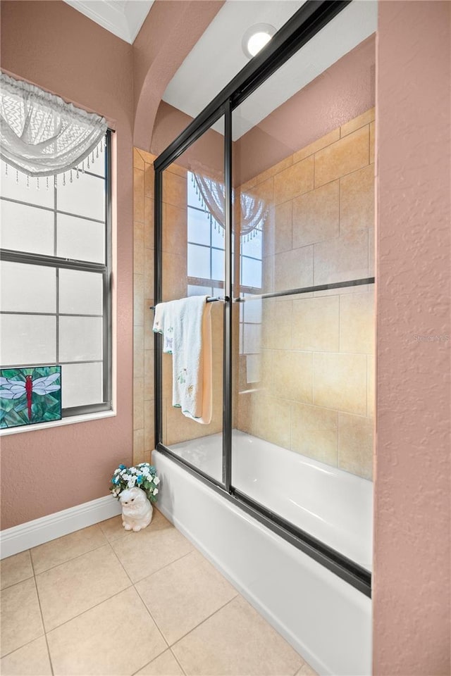 bathroom with tile patterned floors, ornamental molding, and bath / shower combo with glass door