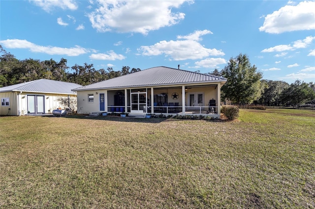 rear view of property featuring a lawn and a sunroom