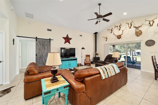 living room featuring a barn door, vaulted ceiling, ceiling fan, and light tile patterned flooring