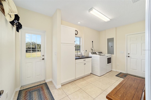 washroom with electric panel, sink, light tile patterned flooring, and cabinets