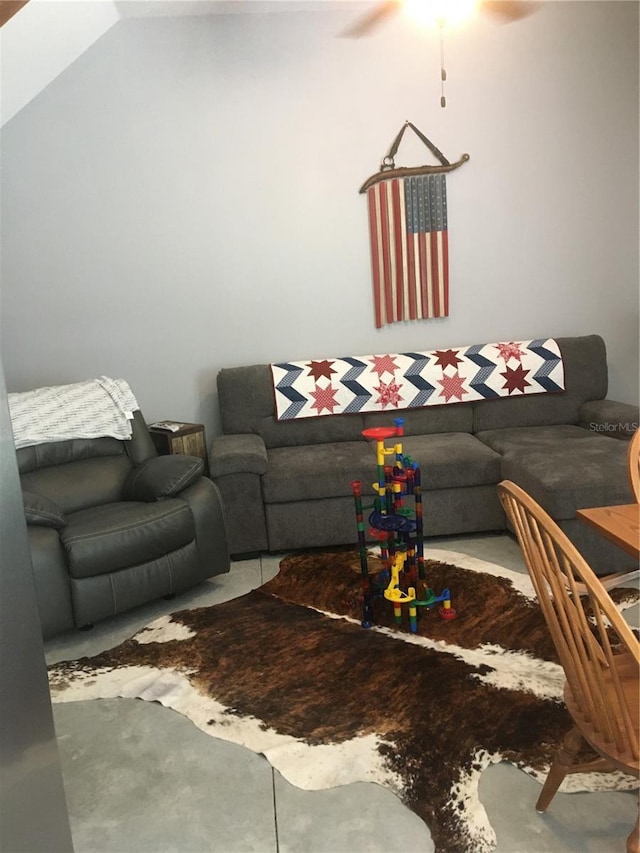 living room with ceiling fan and vaulted ceiling