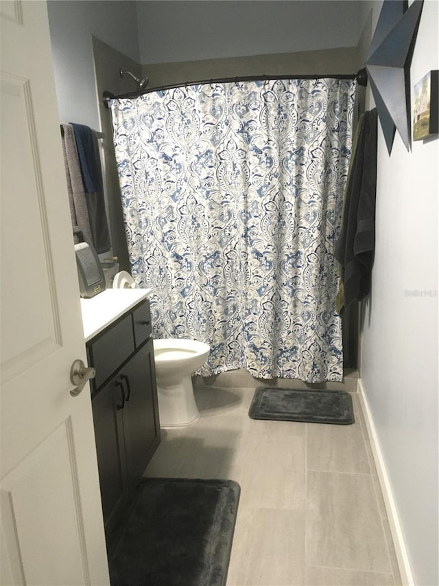 bathroom featuring toilet, vanity, tile patterned floors, and curtained shower