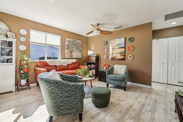 living room with ceiling fan and light hardwood / wood-style flooring