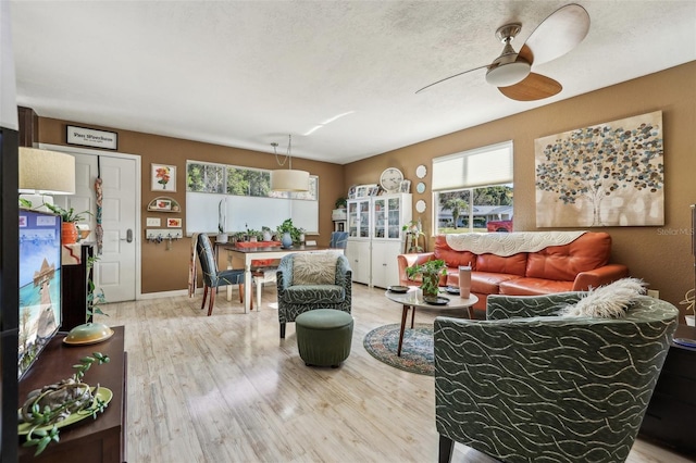 living room featuring hardwood / wood-style floors, a wealth of natural light, a textured ceiling, and ceiling fan