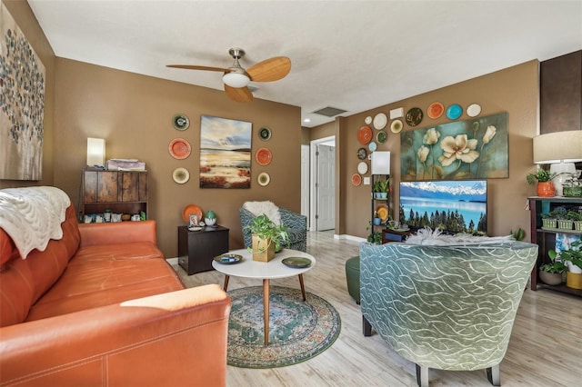 living room with wood-type flooring and ceiling fan