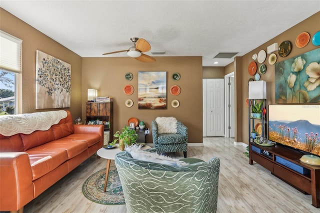 living room with wood-type flooring and ceiling fan