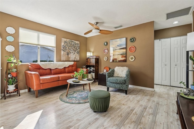 living room featuring ceiling fan and light hardwood / wood-style flooring