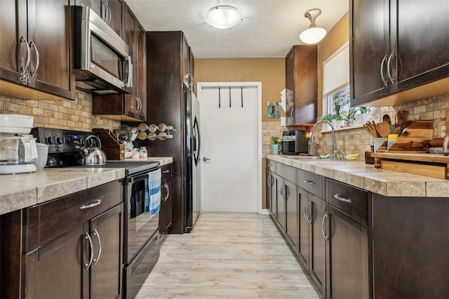 kitchen with dark brown cabinets, sink, electric range, and backsplash