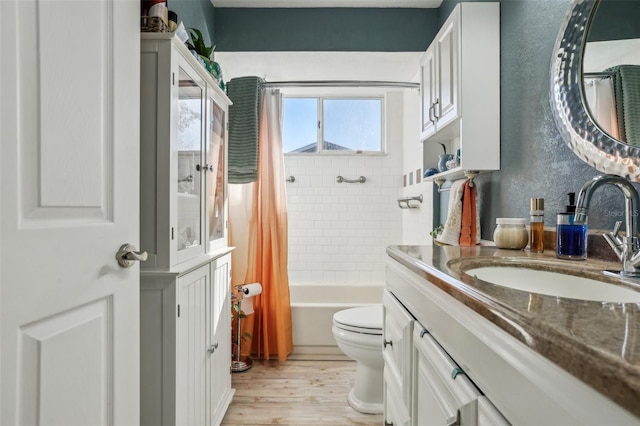 full bathroom with shower / tub combo, vanity, hardwood / wood-style floors, and toilet