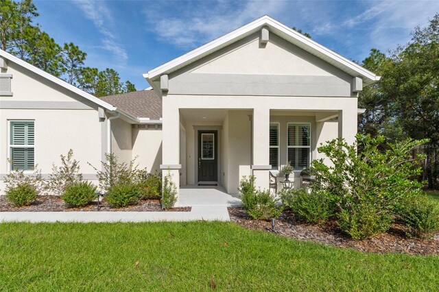 5477 N Princewood Dr, Beverly Hills, FL 34465 - view of front of house featuring stucco siding, a front yard, a porch, and a shingled roof