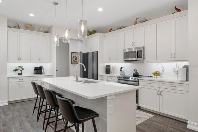 5477 N Princewood Dr, Beverly Hills, FL 34465 - kitchen featuring stainless steel appliances, decorative backsplash, wood finished floors, a kitchen island with sink, and a breakfast bar area