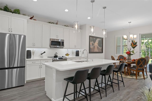 5477 N Princewood Dr, Beverly Hills, FL 34465 - kitchen with appliances with stainless steel finishes, an island with sink, light wood-style floors, tasteful backsplash, and recessed lighting