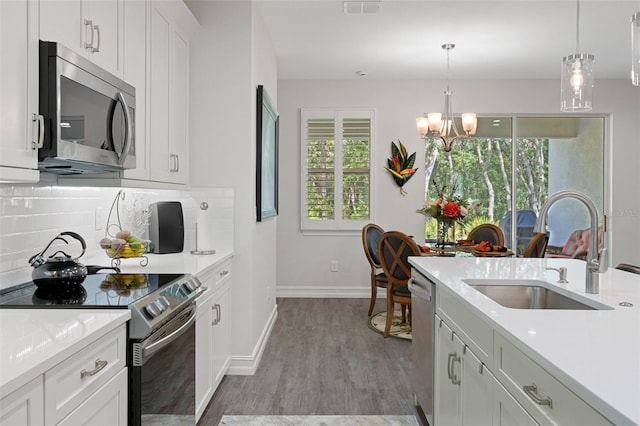 5477 N Princewood Dr, Beverly Hills, FL 34465 - kitchen with appliances with stainless steel finishes, a chandelier, light countertops, and tasteful backsplash