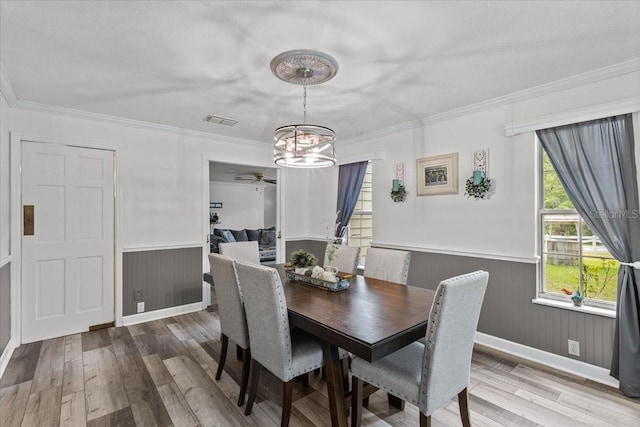 dining area with hardwood / wood-style flooring, ceiling fan with notable chandelier, and ornamental molding