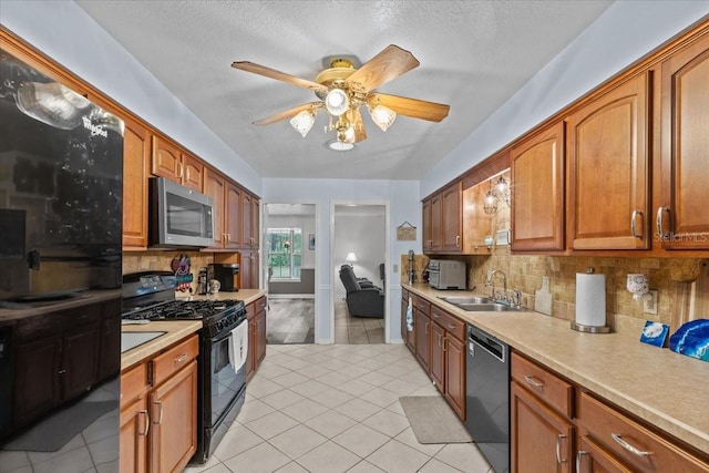 kitchen with black appliances, sink, ceiling fan, light tile patterned floors, and tasteful backsplash