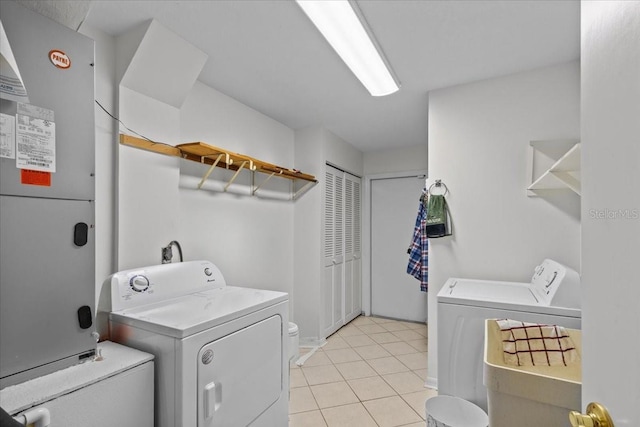 washroom featuring heating unit, light tile patterned flooring, and independent washer and dryer