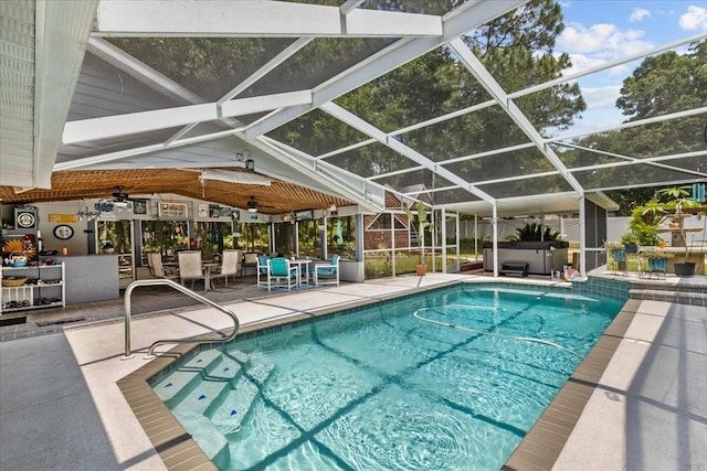 view of swimming pool featuring glass enclosure, ceiling fan, and a patio area