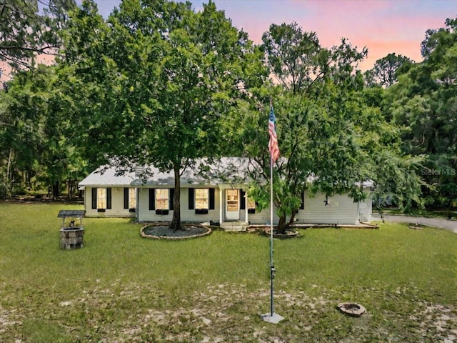 ranch-style home with a yard