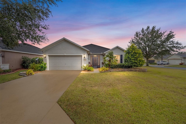 ranch-style house featuring a garage and a lawn