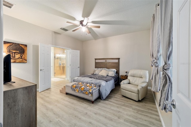 bedroom featuring a textured ceiling, light wood-type flooring, ensuite bathroom, and ceiling fan