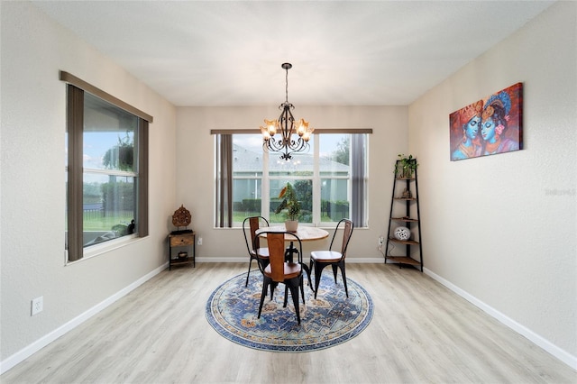 dining space with light hardwood / wood-style flooring and a chandelier