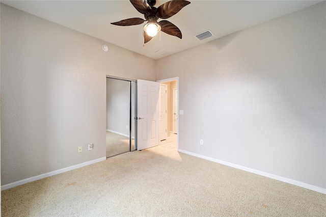 unfurnished bedroom with ceiling fan, light carpet, and a closet