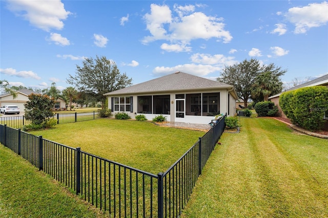 rear view of property featuring a sunroom and a lawn