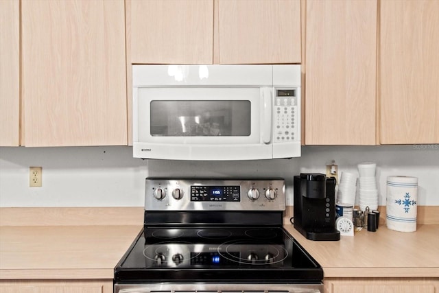 kitchen featuring range with electric cooktop and light brown cabinetry