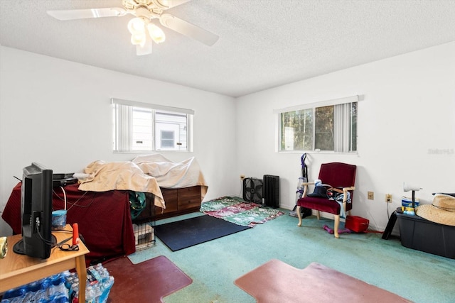 bedroom featuring a textured ceiling, carpet floors, and ceiling fan