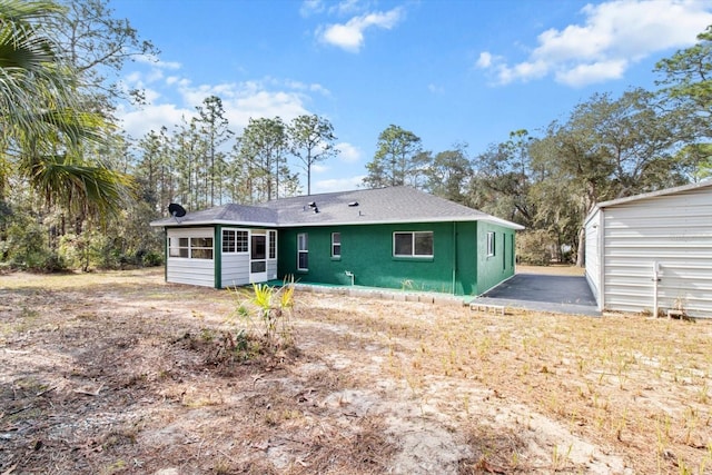 back of property with an outdoor structure and a garage