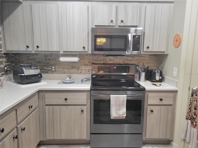 kitchen featuring decorative backsplash, appliances with stainless steel finishes, and light brown cabinets