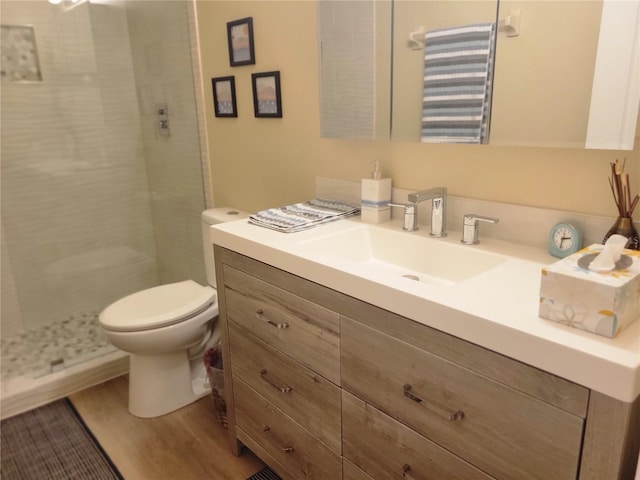 bathroom featuring vanity, hardwood / wood-style flooring, toilet, and walk in shower