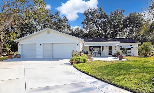 ranch-style house featuring a porch, a garage, and a front lawn