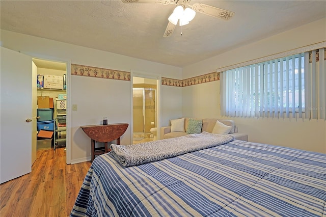 bedroom with ensuite bath, ceiling fan, a textured ceiling, and hardwood / wood-style flooring