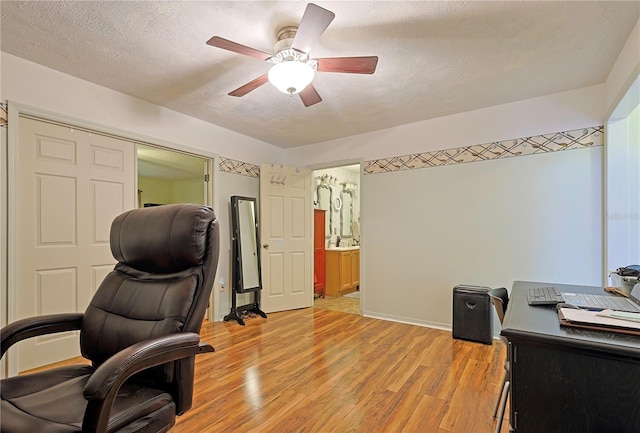 office space with ceiling fan, light hardwood / wood-style floors, and a textured ceiling