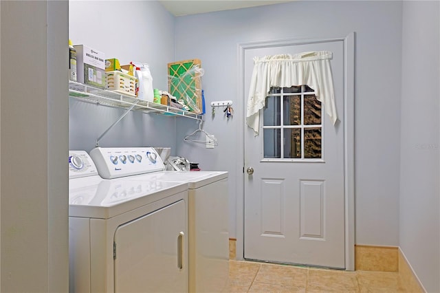 washroom with light tile patterned floors and washing machine and dryer