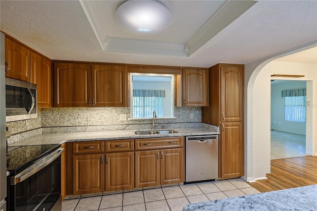 10185 SE 175th Ln, Summerfield, FL 34491 - kitchen with appliances with stainless steel finishes, a sink, brown cabinets, and crown molding
