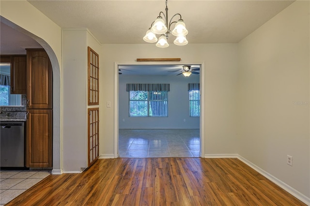 10185 SE 175th Ln, Summerfield, FL 34491 - unfurnished dining area featuring arched walkways, wood finished floors, a chandelier, ceiling fan, and baseboards