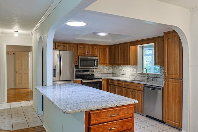 10185 SE 175th Ln, Summerfield, FL 34491 - kitchen with appliances with stainless steel finishes, a sink, arched walkways, light tile patterned flooring, and ornamental molding