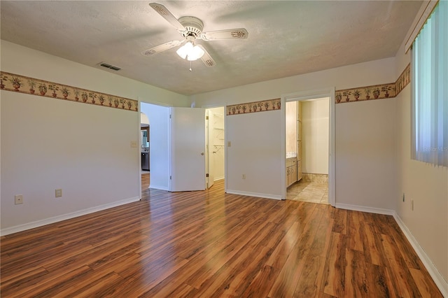10185 SE 175th Ln, Summerfield, FL 34491 - unfurnished room featuring wood finished floors, ceiling fan, baseboards, arched walkways, and a textured ceiling