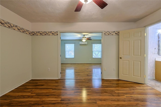 10185 SE 175th Ln, Summerfield, FL 34491 - unfurnished room featuring ceiling fan, wood finished floors, a wall mounted AC, baseboards, and a textured ceiling