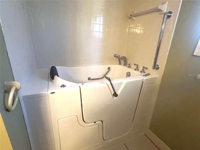 bathroom with tile patterned floors and a bathtub