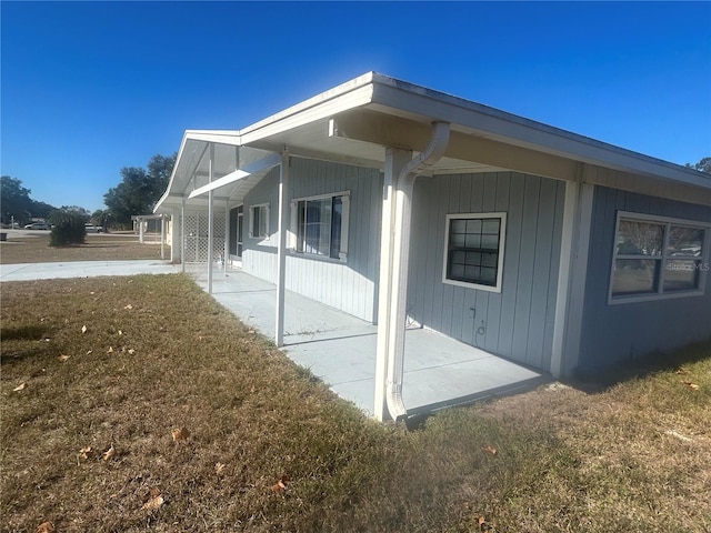 view of property exterior with a patio area and a yard