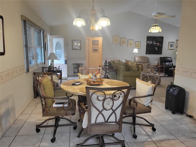 dining area with vaulted ceiling, light tile patterned floors, and ceiling fan with notable chandelier